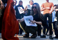 <p>A woman sets fire to a headscarf in Sulaymaniyah, Iraq, on Sept. 19. </p>