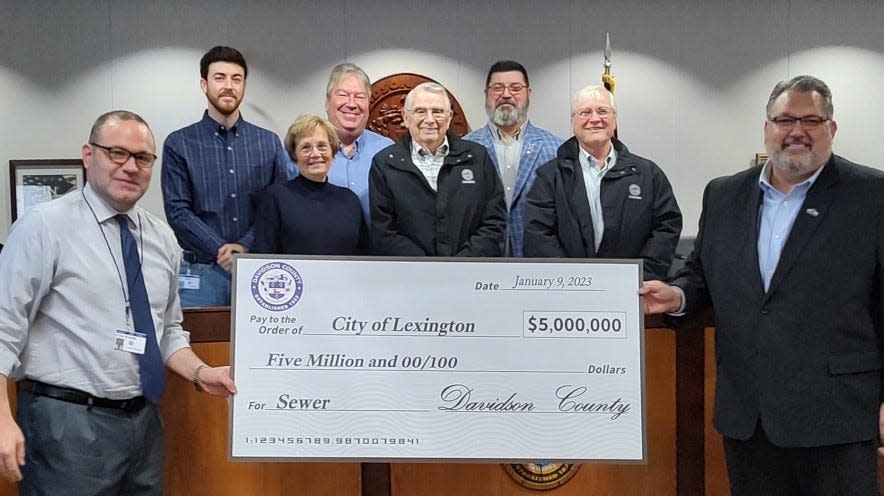 Lexington Mayor Jason Hayes (left) accepts a check for $5 million from Davidson County Manager Casey Smith and members of the Davidson County Board of Commissioners for expansion of wastewater sewage capacity.