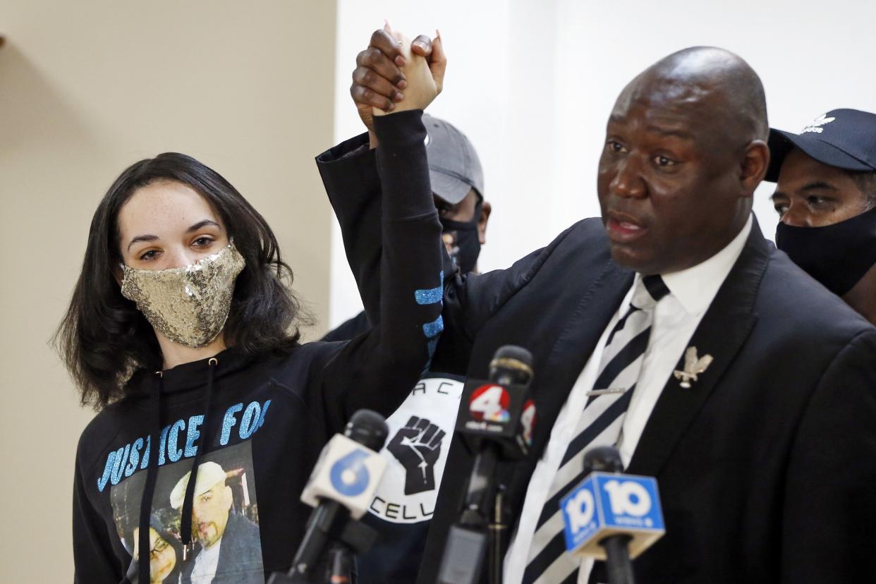 Ben Crump, right, the civil rights attorney representing Andre Hill's family, raises hands with Andre Hill's Daughter Karissa Hill during a news conference about the indictment of Columbus Police Officer Adam Coy in the shooting death of Andre Hill on Feb. 4, in Columbus, Ohio. 