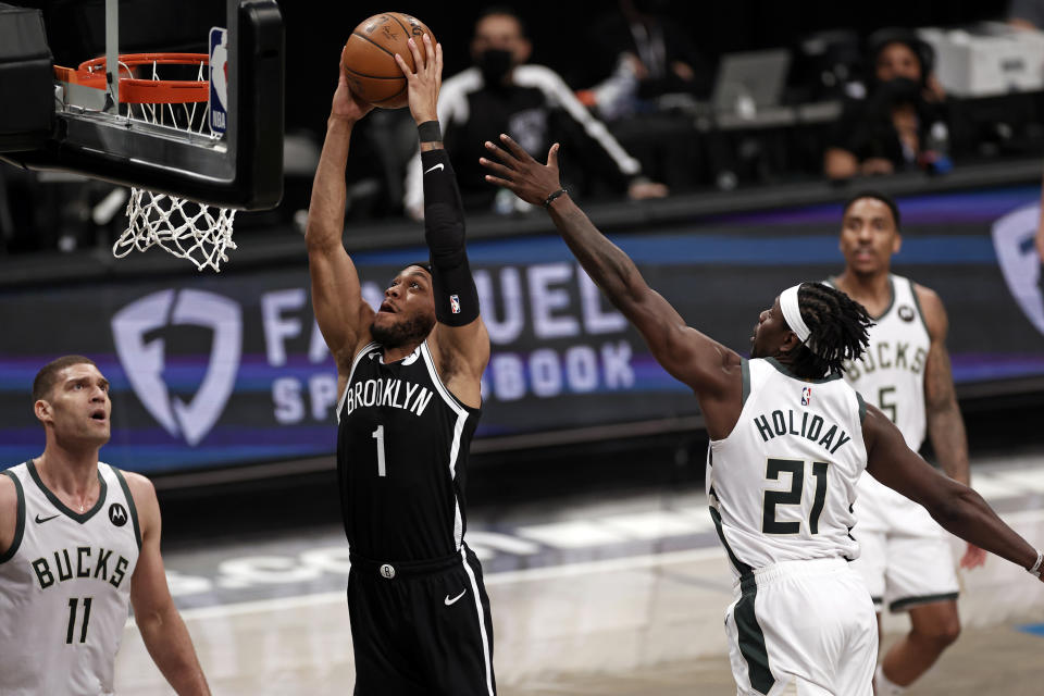 Brooklyn Nets forward Bruce Brown (1) dunks the ball past Milwaukee Bucks guard Jrue Holiday (21) during the second half of Game 1. (AP Photo/Adam Hunger)