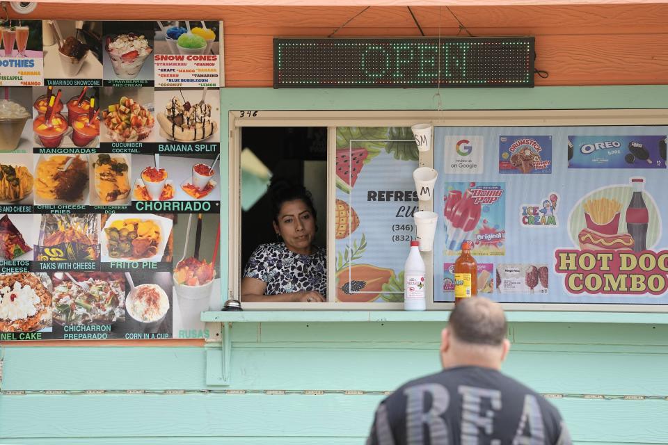 Manuela Lara looks out from her food stand as a customer approaches Tuesday, May 2, 2023, in the neighborhood where a mass shooting occurred last week, in Cleveland, Texas. “It’s very hard because nothing like this has ever happened,” said Lara, who would often see Wilson Garcia and his family at the neighborhood Mexican food stand that she owns. Garcia's wife and son were among the victims killed in the shooting. (AP Photo/David J. Phillip)