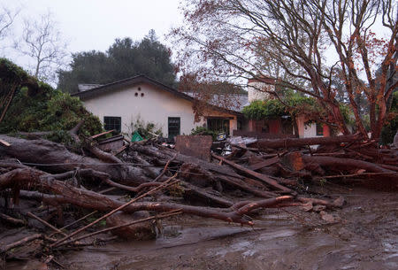 A home seen surrounded by flooded water and debris after a mudslide in Montecito, California, U.S. January 9, 2018. Kenneth Song/Santa Barbara News-Press via REUTERS