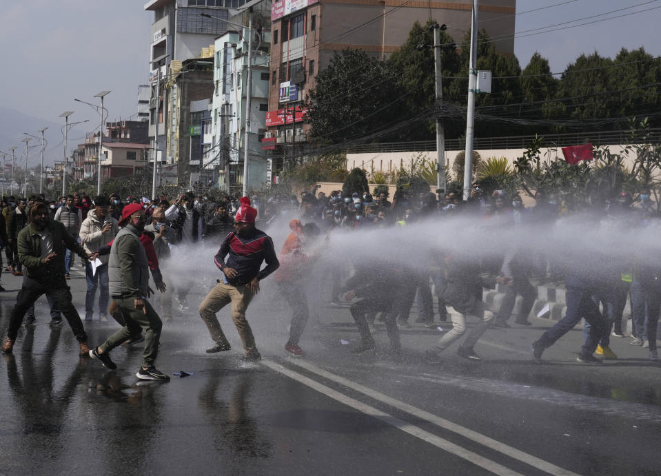 Nepalese protesters opposing a proposed U.S. half billion dollars grant for Nepal clash with police outside as the parliament debates the contentious aid in Kathmandu, Nepal, Sunday, Feb. 20, 2022. Opposition to the grant comes mainly from two Communist parties that are part of the coalition government who claim the conditions in the grant agreement will prevail over Nepal's laws and threaten the country's sovereignty. (AP Photo/Niranjan Shreshta)