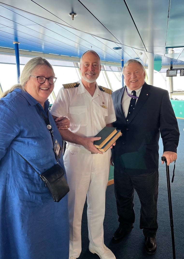 Judy Shaw, left, Capt. Evans Hoyt, and Bruce Shaw on the bridge of Queen Victoria.