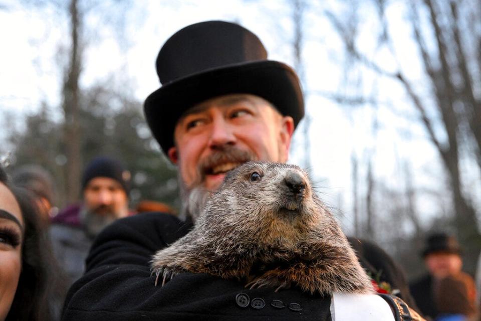 Groundhog Club handler A.J. Dereume holds Punxsutawney Phil, the weather prognosticating groundhog, during the 136th celebration of Groundhog Day on Gobbler's Knob in Punxsutawney, Pa., Wednesday, Feb. 2, 2022. Phil's handlers said that the groundhog has forecast six more weeks of winter. (AP Photo/Barry Reeger)