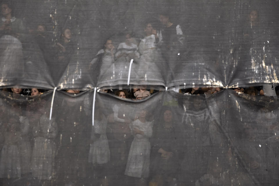 Ultra-Orthodox Jewish women are seen behind a curtain during the "Pidyon Haben" ceremony for Yossef Tabersky, a 30-day-old great grandchild of the chief rabbi of the Lelov Hassidic dynasty, in Beit Shemesh, Israel, Thursday, Sept. 16, 2021. The Pidyon Haben, or redemption of the firstborn son, is a Jewish ceremony hearkening back to the biblical exodus from Egypt. (AP Photo/Oded Balilty)