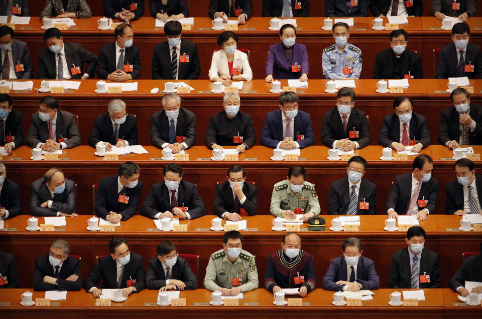 Delegates wearing face masks to protect against the spread of the new coronavirus wait for the start of the opening session of the Chinese People's Political Consultative Conference (CPPCC) at the Great Hall of the People in Beijing, Thursday, May 21, 2020. (AP Photo/Andy Wong, Pool)