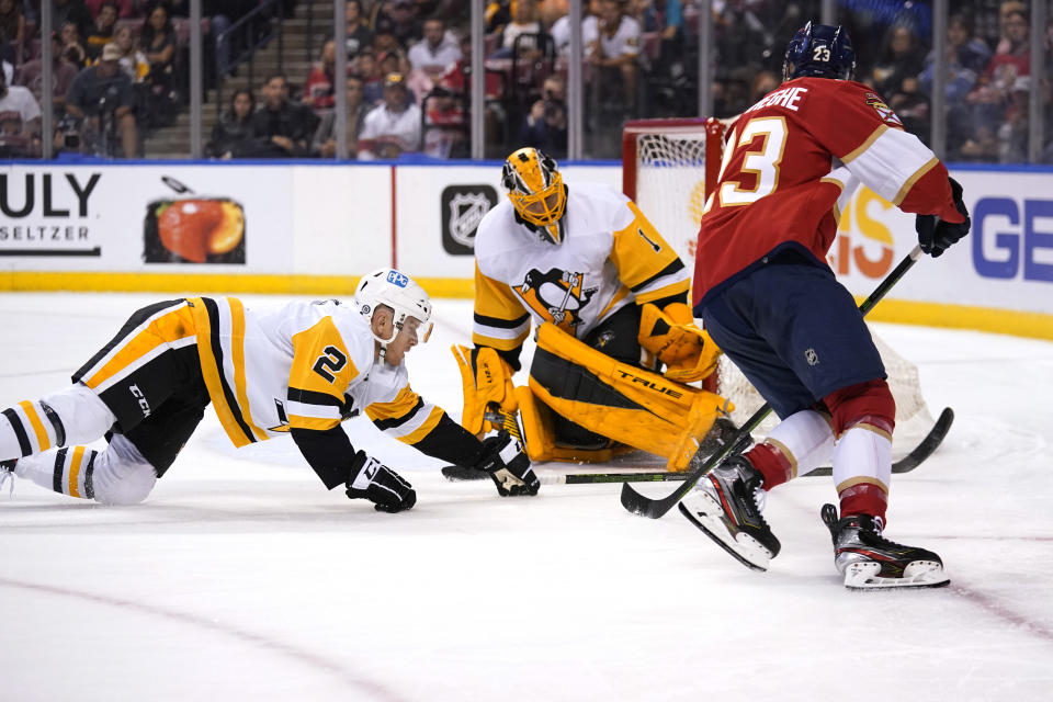 Pittsburgh Penguins defenseman Chad Ruhwedel (2) and goaltender Casey DeSmith, center, defend as Florida Panthers left wing Carter Verhaeghe (23) attempts a shot during the second period of an NHL hockey game Thursday, Oct. 14, 2021, in Sunrise, Fla. (AP Photo/Lynne Sladky)