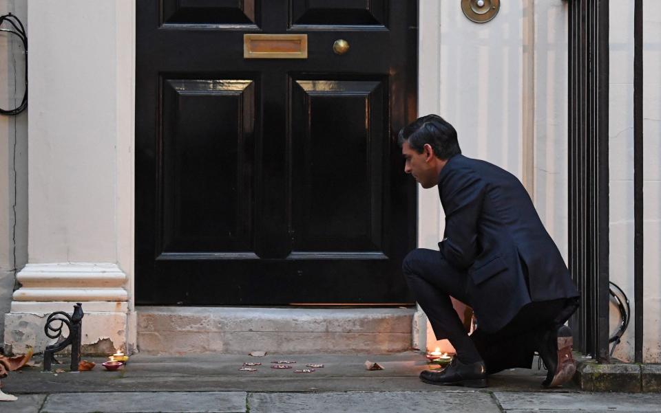 Mr Sunak lights candles outside Number 11 Downing Street ahead of Diwali celebrations - Stefan Rousseau/PA