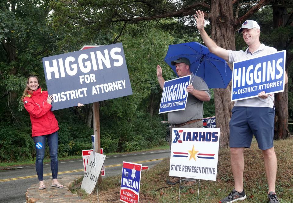 Republican candidate for Cape and Islands District Attorney Dan Higgins (right) waves to supporters with his wife, Elizabeth Higgins, and his friend, Tim Morley, at the West Barnstable polls on Route 149 Tuesday afternoon. By 5:45 a.m. Wednesday, Higgins was declared the winner in the Republican primary race.