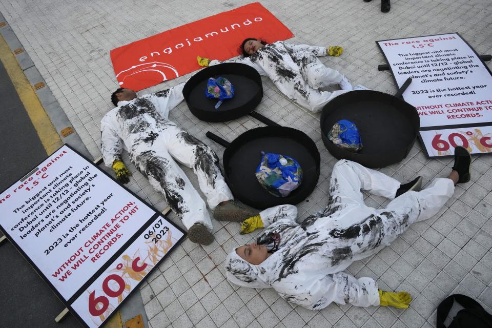Activists participate in a die-in against fossil fuels at the COP28 U.N. Climate Summit, Saturday, Dec. 9, 2023, in Dubai, United Arab Emirates. (AP Photo/Peter Dejong)