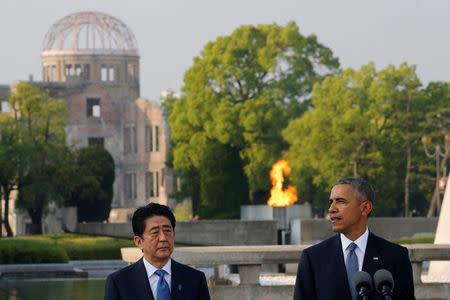 U.S. President Barack Obama (R), flanked by Japanese Prime Minister Shinzo Abe, delivers a speech as the atomic bomb dome is background after they laid wreaths to a cenotaph at Hiroshima Peace Memorial Park in Hiroshima, Japan May 27, 2016. REUTERS/Carlos Barria