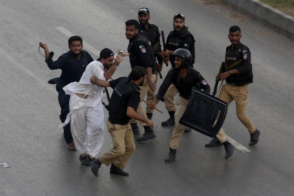 Police officers detain a supporter of former Pakistani Prime Minister Imran Khan's party, 'Pakistan Tehreek-e-Insaf' during a protest to condemn a shooting incident on their leader's convoy, in Karachi, Pakistan, Friday, Nov. 4, 2022. Khan who narrowly escaped an assassination attempt on his life the previous day when a gunman fired multiple shots and wounded him in the leg during a protest rally is listed in stable condition after undergoing surgery at a hospital, a senior leader from his party said Friday. (AP Photo/Fareed Khan)