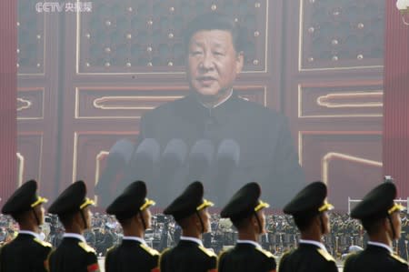 Soldiers of People's Liberation Army (PLA) are seen before a giant screen as Chinese President Xi Jinping speaks at the military parade marking the 70th founding anniversary of People's Republic of China