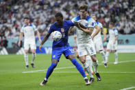 Haji Wright of the United States, left, and England's John Stones fight for the ball during the World Cup group B soccer match between England and The United States, at the Al Bayt Stadium in Al Khor , Qatar, Friday, Nov. 25, 2022. (AP Photo/Ashley Landis)