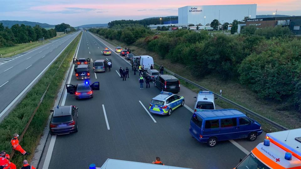 Polizisten und Helfer stehen mit ihren Fahrzeugen auf der Autobahn 9.