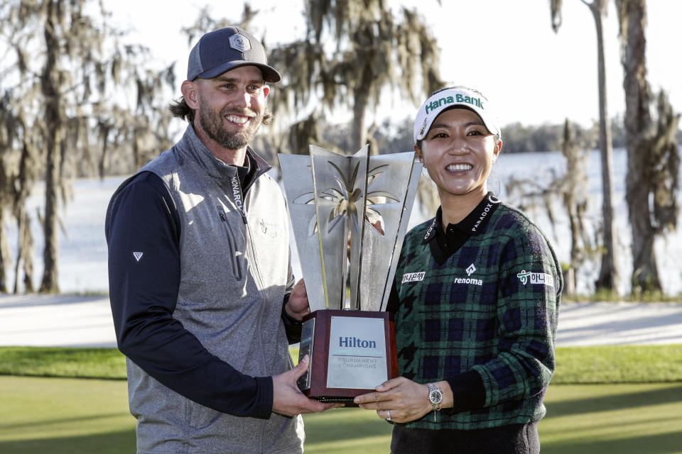 Celebrity winner Jeff McNeil, left, and LPGA winner Lydia Ko, right, hold the trophy after the final round of the Hilton Grand Vacations Tournament of Champions LPGA golf tournament in Orlando, Fla., Sunday, Jan. 21, 2024. (AP Photo/Kevin Kolczynski)