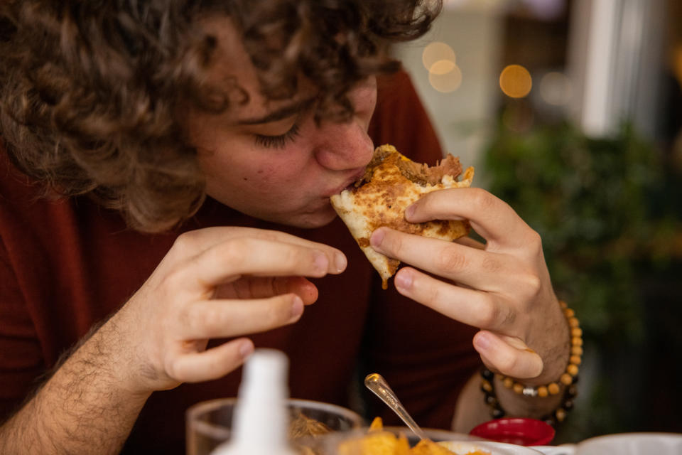 Man tucking into a dinner sandwich. (Getty Images)