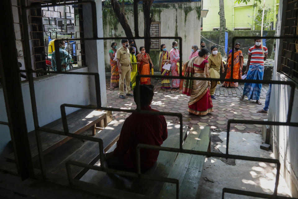 People wait to register their names to receive COVID-19 vaccine at a health center in Garia , South 24 Pargana district, India, Thursday, Oct. 21, 2021. India has administered 1 billion doses of COVID-19 vaccine, passing a milestone for the South Asian country where the delta variant fueled its first crushing surge this year. (AP Photo/Bikas Das)