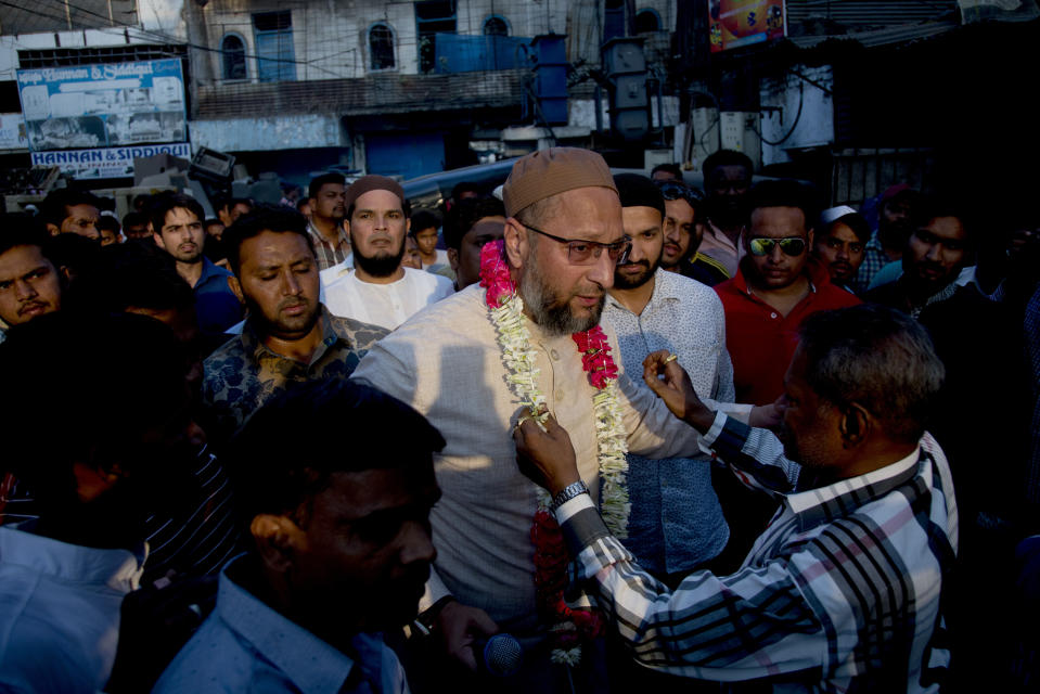 An Indian supporter present a floral garland to All India Majlis-e-Ittehadul Muslimeen (AIMIM) President Asaduddin Owaisi, center, during an election campaign in Hyderabad, India, Tuesday, March 26, 2019. India's national election will be held in seven phases between April 11 and May 19. (AP Photo/ Mahesh Kumar A.)