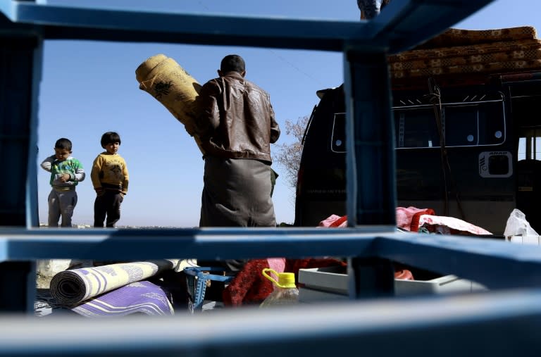 A displaced Syrian family unload their belongings at a makeshift camp for displaced people near the town of Manbij, northern Syria on March 6, 2017