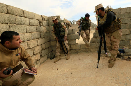 Iraqi soldiers take cover during an operation against Islamic State militants in the frontline in neighbourhood of Intisar, eastern Mosul, Iraq, December 5, 2016. REUTERS/Thaier Al-Sudani