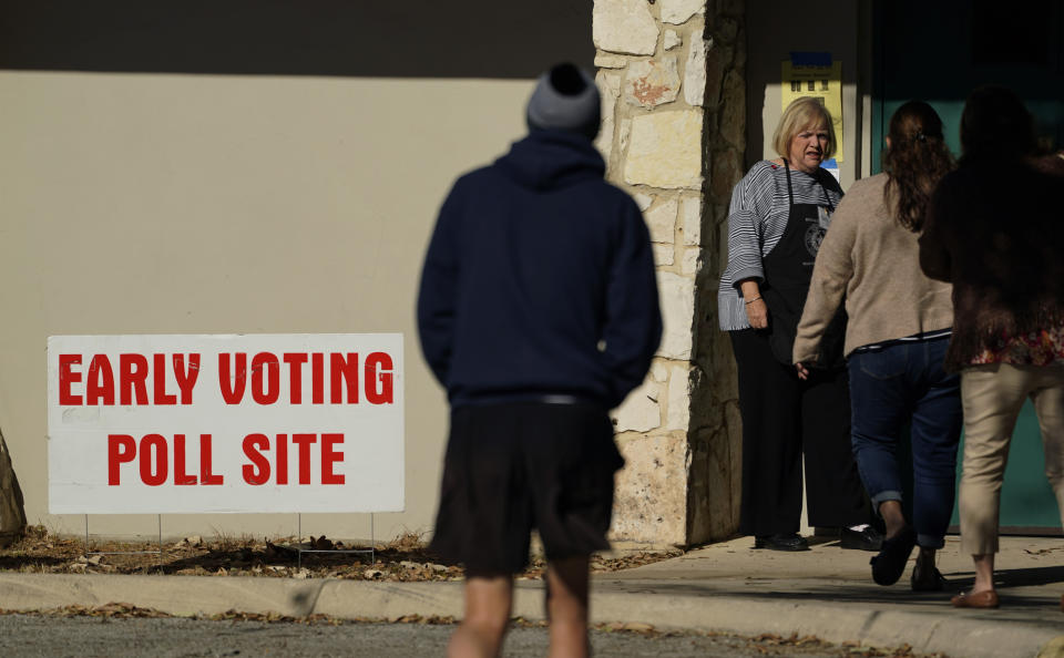 A poll worker meets voters at the entrance to an early voting site, Monday, Feb. 14, 2022, in San Antonio. Early voting in Texas began Monday. (AP Photo/Eric Gay)