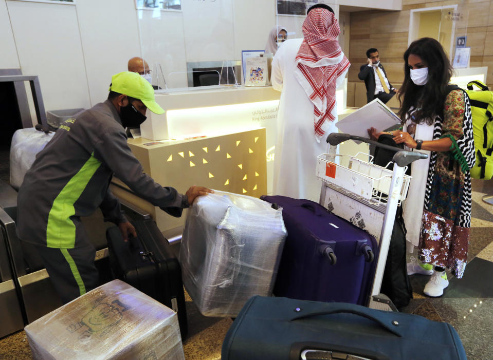 Saudi passenger Hanan Yousef, 35, checks her baggage for a trip to Egypt for tourism, at King Abdulaziz International Airport in Jiddah, Saudi Arabia, Monday, May 17, 2021. Vaccinated Saudis are allowed to leave the kingdom for the first time in more than a year as the country eases a ban on international travel that had been in place to try and contain the spread of the coronavirus and its new variants. (AP Photo/Amr Nabil)