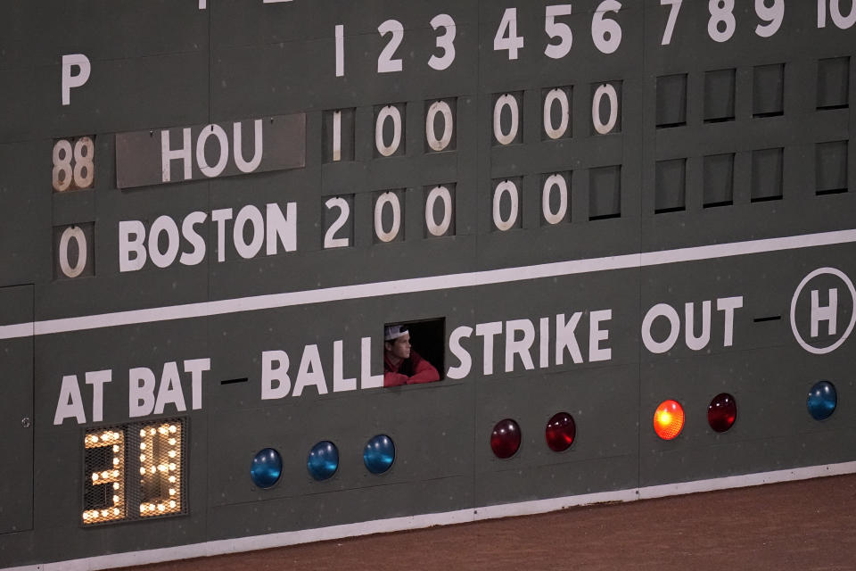 A scoreboard worker watches during the sixth inning in Game 4 of baseball's American League Championship Series between the Houston Astros and the Boston Red Sox Tuesday, Oct. 19, 2021, in Boston. (AP Photo/Charles Krupa)