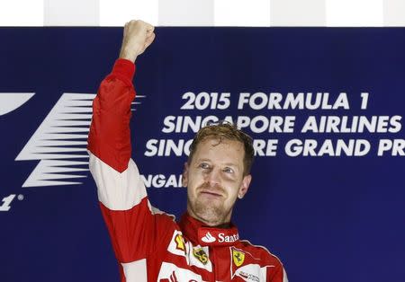 Ferrari Formula One driver Sebastian Vettel of Germany celebrates on the podium after winning the Singapore F1 Grand Prix at the Marina Bay street circuit September 20, 2015. REUTERS/Olivia Harris