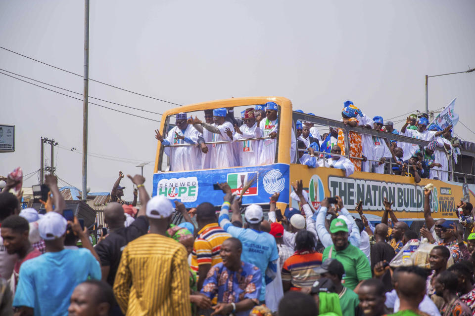 Bola Ahmed Tinubu, foreground right, presidential candidate of the All Progressives Congress, Nigeria ruling party, rides on a double decker bus during an election campaign rally in Lagos Nigeria, Tuesday, Feb 21, 2023. (AP Photo/ Efunla Ayodele)