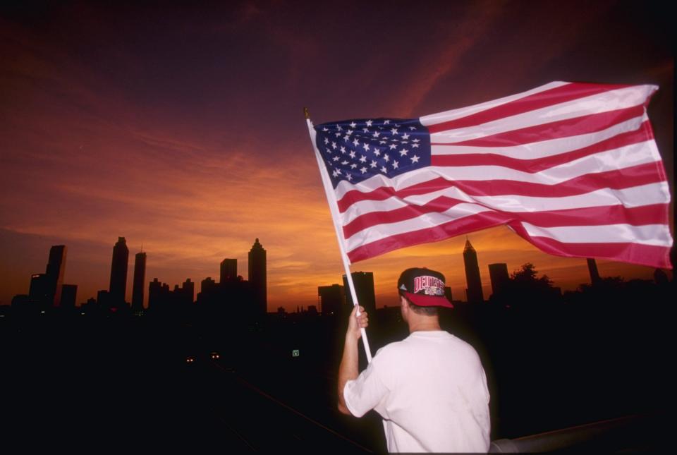 An American flag is waved during the Opening Ceremony of the 1996 Centennial Olympic Games at the Olympic Stadium in Atlanta, Georgia.