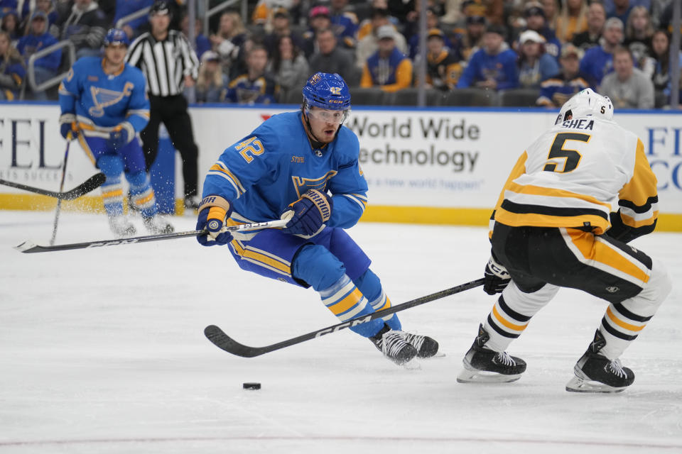 St. Louis Blues' Kasperi Kapanen (42) and Pittsburgh Penguins' Ryan Shea (5) battle for a loose puck during the second period of an NHL hockey game Saturday, Oct. 21, 2023, in St. Louis. (AP Photo/Jeff Roberson)