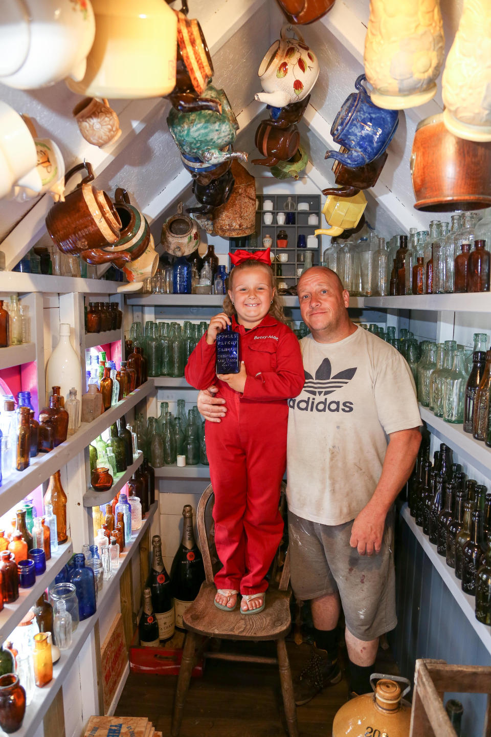 A seven-year-old schoolgirl is raking in hundreds of pounds by selling antique bottles from a little shop in her back garden - after digging them up from old landfill sites. Betsy-Mae Lloyd has been coining it in after launching her own business at her parents' home while still attending primary school.  The young entrepreneur flogs old bottles, jars and teapots - dating back to between the 1870s and 1930 - which she finds on historic landfill sites in the West Midlands.  After taking them home and cleaning them up herself, she then stores them in a Victorian-style play shed, built by dad Jason, before listing them for sale on Facebook. 