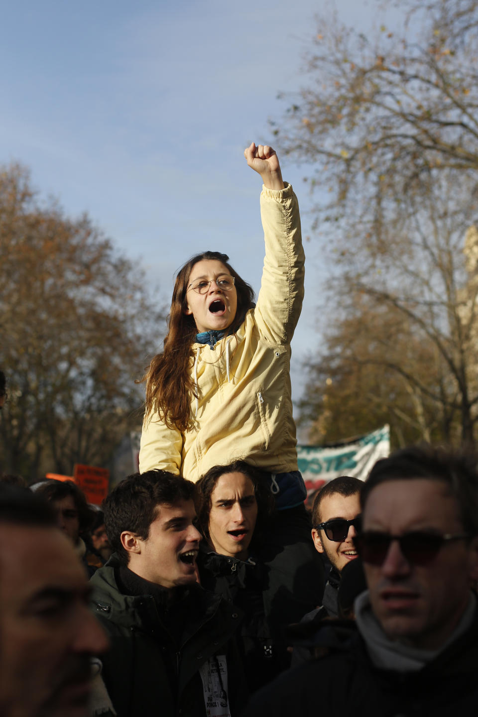 A woman clenches her fist during a demonstration Tuesday, Dec. 10, 2019 in Paris. French airport employees, teachers and other workers joined nationwide strikes Tuesday as unions cranked up pressure on the government to scrap upcoming changes to the country's national retirement system. (AP Photo/Thibault Camus)