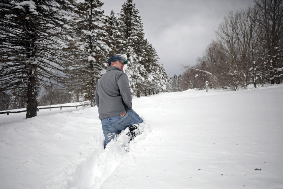 Rich Lampron tries to walk a few steps through the unplowed driveway to his Bates Rd. property in Windsor, Mass. on Wednesday, March 15, 2023, before giving up on the endeavor as the snow rose nearly to his waist. (Stephanie Zollshan/The Berkshire Eagle via AP)