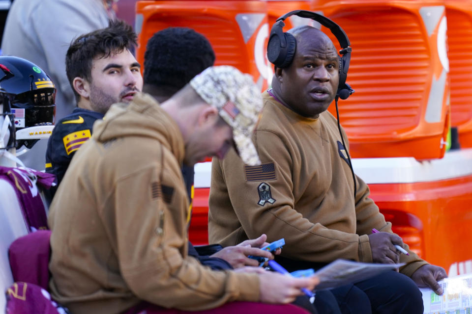 Washington Commanders offensive coordinator Eric Bieniemy, right, talks with Washington Commanders quarterback Sam Howell (14), left, during the first half of an NFL football game against the New York Giants, Sunday, Nov. 19, 2023, in Landover, Md. (AP Photo/Stephanie Scarbrough)