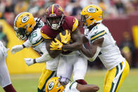 Green Bay Packers safety Darnell Savage, left, and safety Adrian Amos, right, combine to tackle Washington Commanders wide receiver Curtis Samuel during the second half of an NFL football game Sunday, Oct. 23, 2022, in Landover, Md. (AP Photo/Susan Walsh)