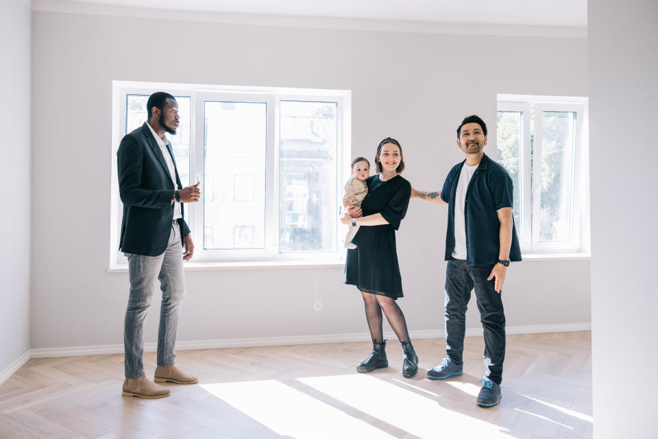Real estate agent giving room tour for young Multi-racial family