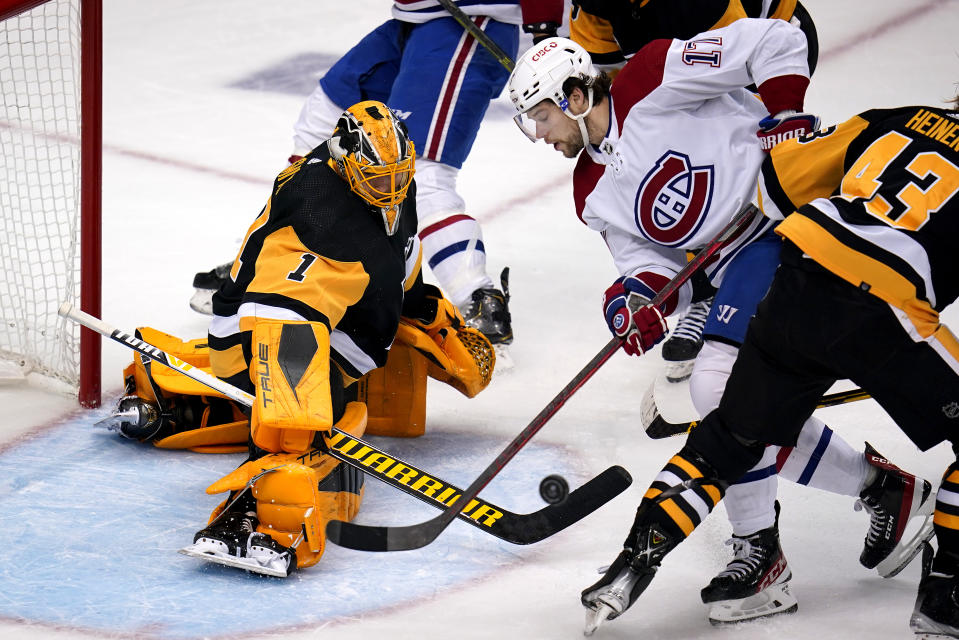 Pittsburgh Penguins goaltender Casey DeSmith (1) blocks a shot by Montreal Canadiens' Josh Anderson (17) with Danton Heinen (43) defending during the first period of an NHL hockey game in Pittsburgh, Saturday, Nov. 27, 2021. (AP Photo/Gene J. Puskar)