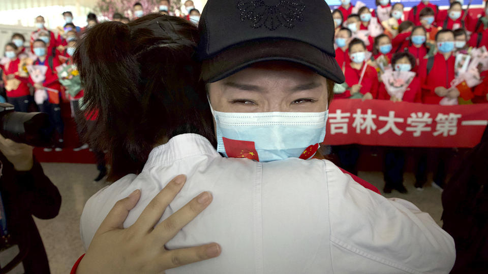 A medical worker from China's Jilin Province reacts as she prepares to return home at Wuhan Tianhe International Airport in Wuhan in central China's Hubei Province, Wednesday, April 8, 2020.  (Ng Han Guan/AP)