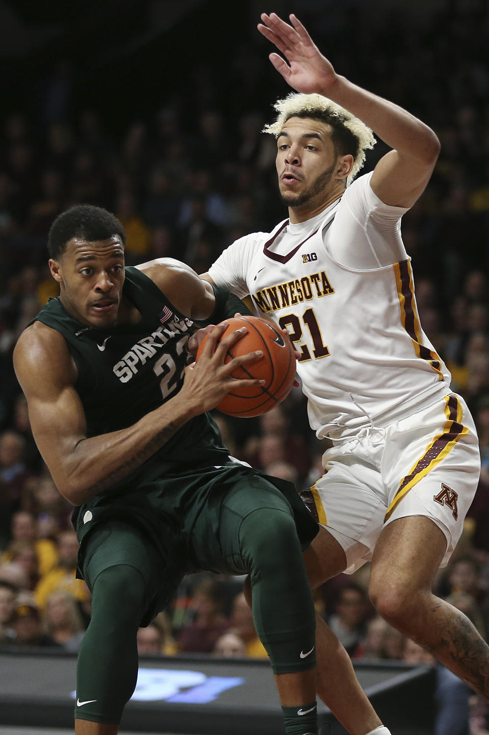 Michigan State's Xavier Tillman, left, handles the ball against Minnesota's Jarvis Omersa during an NCAA college basketball game Sunday, Jan. 26, 2020, in Minneapolis. (AP Photo/Stacy Bengs)