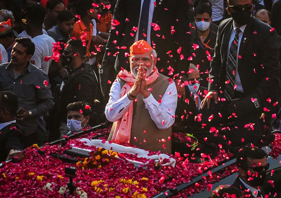 India's Prime Minister Narendra Modi greets crowds of supporters during a roadshow in support of state elections on March 04, 2022 in Varanasi, India.