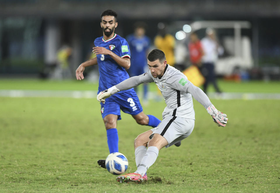 Australia's goalkeeper Mathew Ryan, right, clears the ball past Kuwait's Ahmad Aldhefiri during the World Cup 2022 Group B qualifying soccer match between Kuwait and Australia in Kuwait City, Kuwait, Thursday, June 3, 2021. (AP Photo/Jaber Abdulkhaleg)