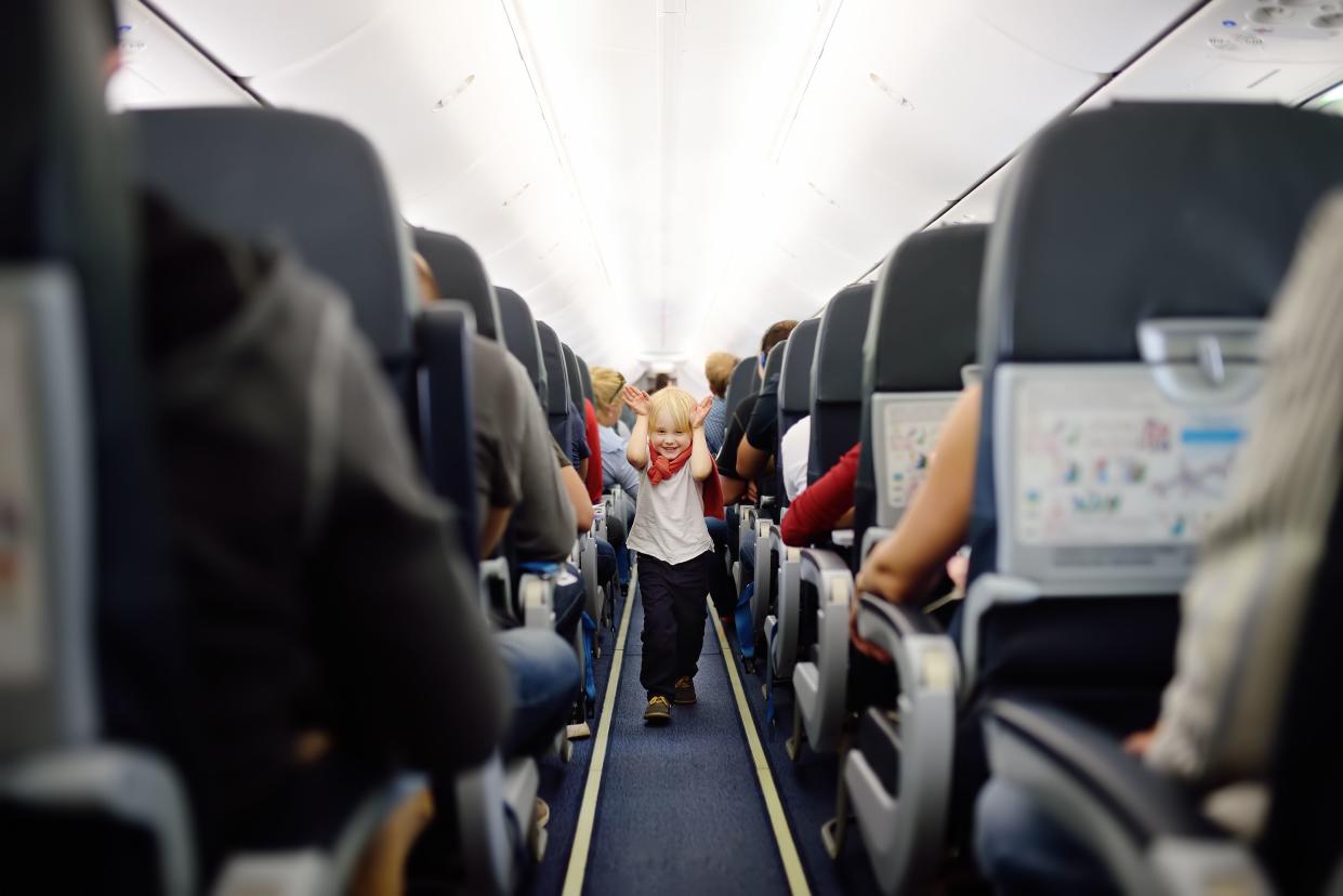 Happy little boy during traveling by an airplane. Traveling with kids. Family enjoying trip in aircraft. Transportation safety