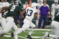 Penn State running back Kaytron Allen (13) breaks through the Michigan State defense during the first half of an NCAA college football game, Friday, Nov. 24, 2023, in Detroit. (AP Photo/Carlos Osorio)