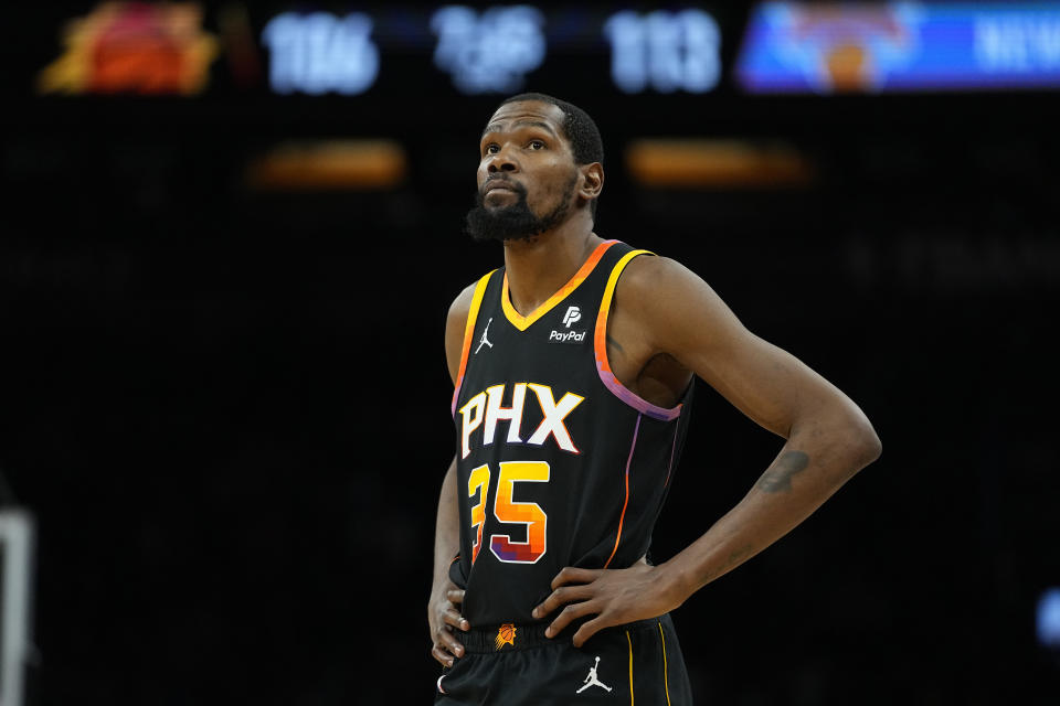 Phoenix Suns forward Kevin Durant (35) looks at the scoreboard during the second half of an NBA basketball game against the New York Knicks, Friday, Dec. 15, 2023, in Phoenix. (AP Photo/Matt York)