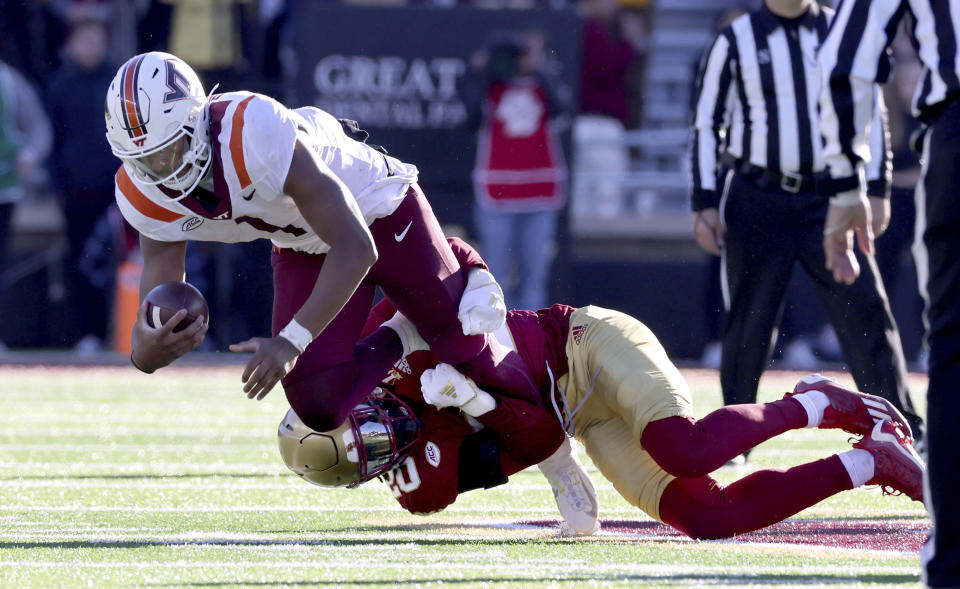 Boston College defensive back KP Price grabs hold of Virginia Tech quarterback Kyron Drones during the second half of an NCAA college football game Saturday, Nov. 11, 2023 in Boston. (AP Photo/Mark Stockwell)