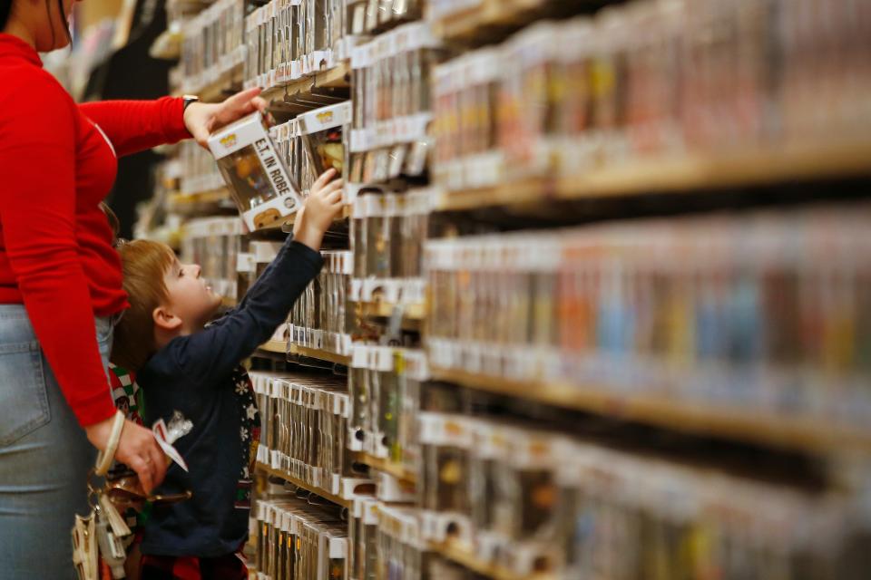 A young boy picks a bobble head inside Newbury Comics in the Dartmouth Mall.