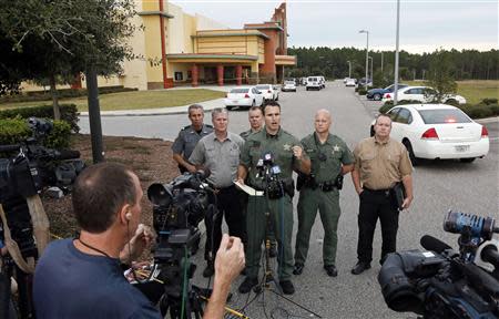 Pasco County Sheriff Chris Nocco (C) speaks to the media as police tape surrounds the Cobb Grove 16 movie theater in Wesley Chapel, Florida, January 13, 2014. REUTERS/Mike Carlson